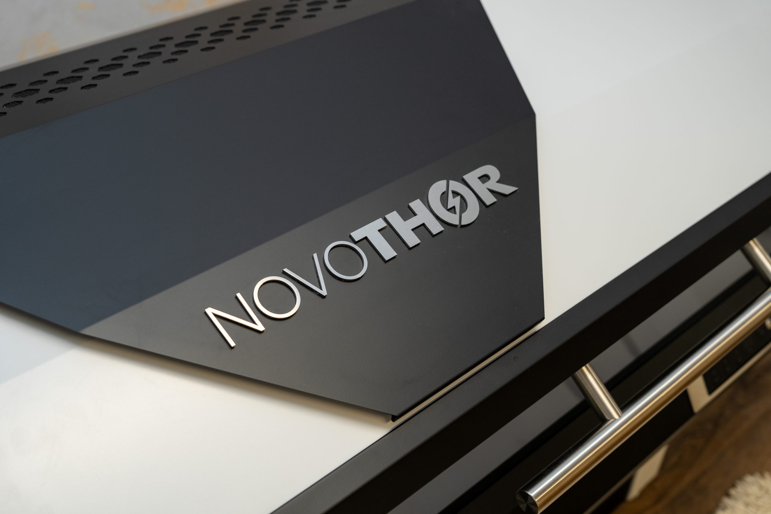 Close-up of a black and white NovoTHOR device, showing the brand name logo prominently on the surface—a trusted tool in wellness and anti-aging treatments at the Institute For Ageless Living.